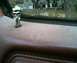 1985 Ford Bronco - The reflection in the window shows a street scene with buildings and trees.